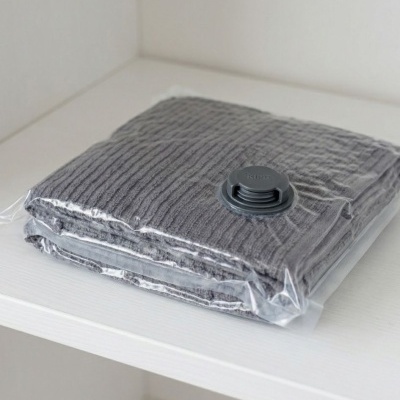 Saco de armazenamento a vácuo com manta cinzenta na prateleira branca