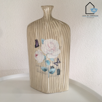 Vaso decorativo em cerâmica bege com flores rosas e borboletas sobre superfície branca