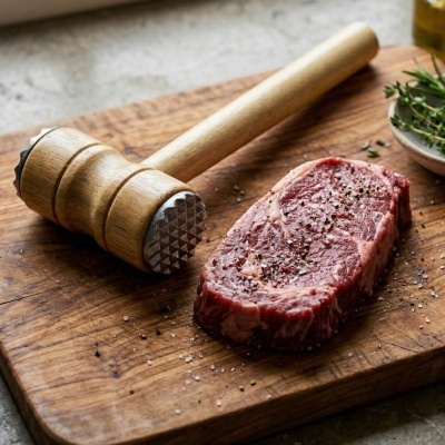 Maço de carne e bife cru temperado em tábua de madeira