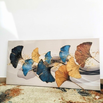 Quadro decorativo com folhas coloridas em azul, castanho e amarelo com detalhes dourados sobre fundo bege.