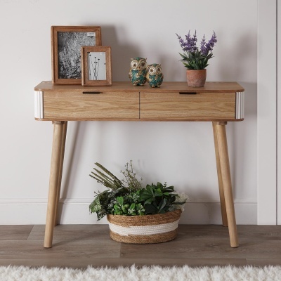 Aparador de madeira clara com decoração e cesta de plantas