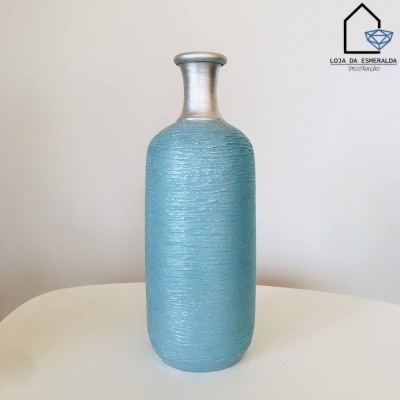 Garrafa decorativa azul turquesa texturizada com pescoço prateado em fundo neutro