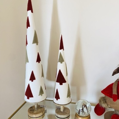 Dois cones decorativos de Natal em tecido branco com árvores verdes e vermelhas.