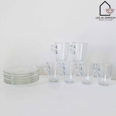 Conjunto de copos de vidro com pega em forma de coração e pratos transparentes sobre mesa branca