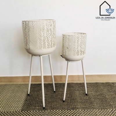 Dois vasos decorativos brancos com padrão de folhagem em suportes metálicos altos