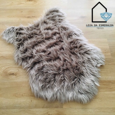 Tapete cinzento de pelo comprido sobre chão de madeira com logótipo de loja ao fundo