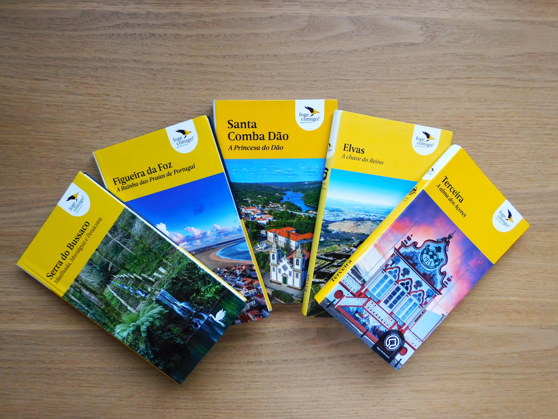 Cinco guias turísticos com capas amarelas e imagens de paisagens e arquitetura