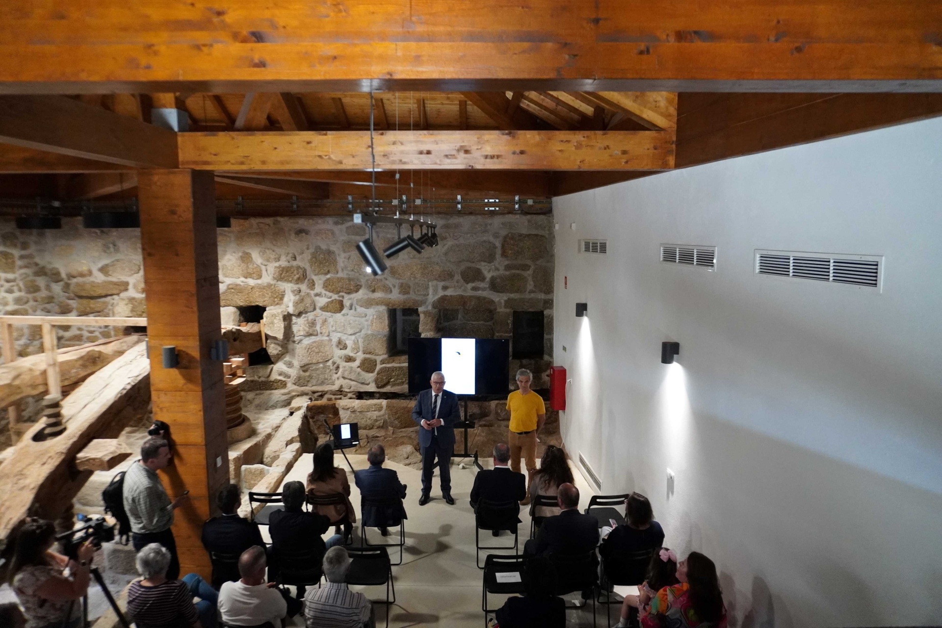 sala de conferências com paredes de pedra e teto de madeira