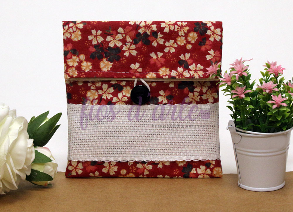 Bolsa Multiusos estampada com quadrilé para bordar ponto cruz (14x15cms) - Florzinhas Carteira em tecido floral vermelho com botão preto, junto a flores brancas e cor-de-rosa em vaso branco