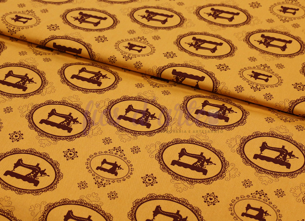 Tecido Máquinas Vintage (Farbicart) - Mostarda Tecido amarelo com padrão de máquinas de costura castanhas em oval.