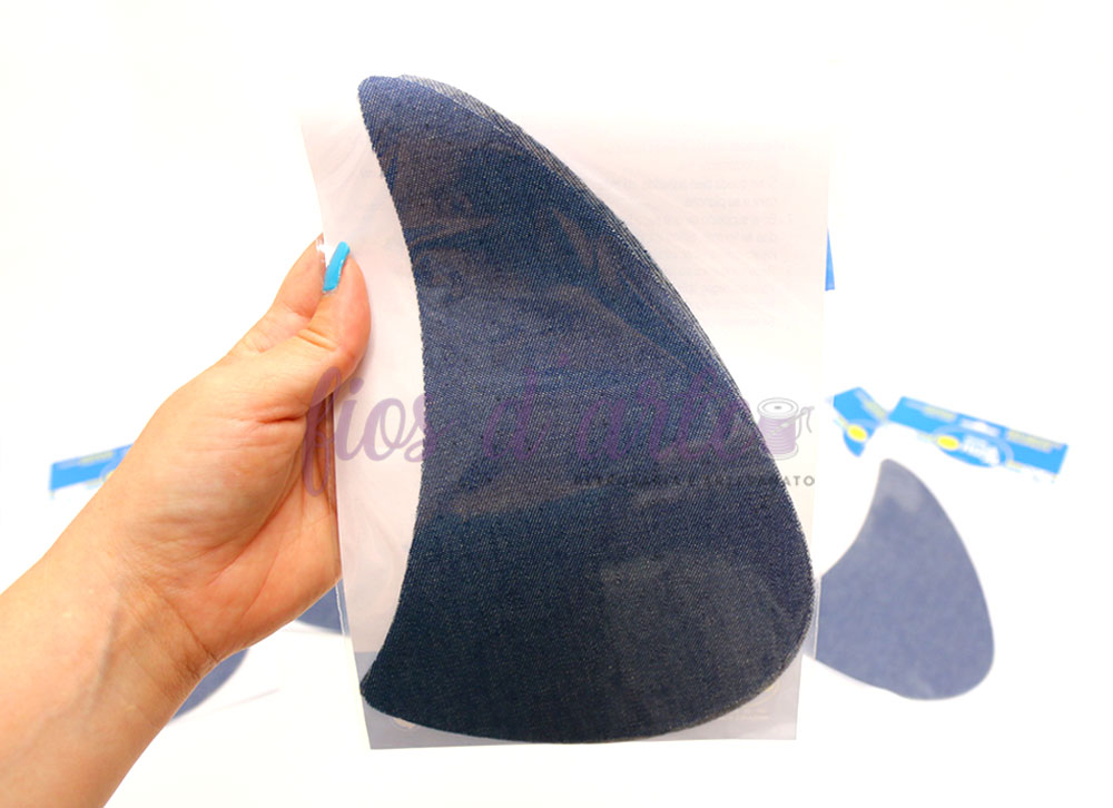 Apoios plantares ortopédicos pretos segurados por mão com unhas azuis com embalagens ao fundo