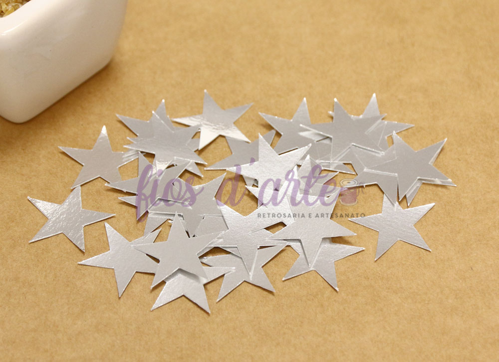 Estrelas decorativas prateadas em superfície bege