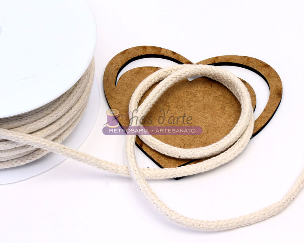 Cordão branco de algodão em forma de coração num cartão castanho sobre fundo branco