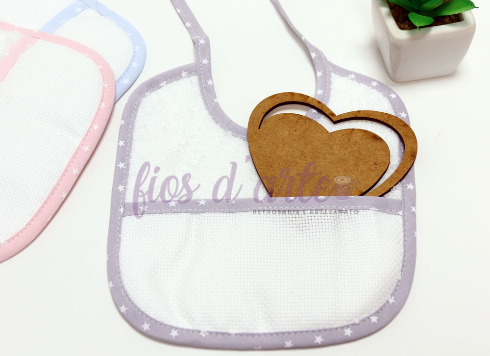 Babete branco com bordas cinzentas e padrão de estrelas, com bolso e coração em madeira