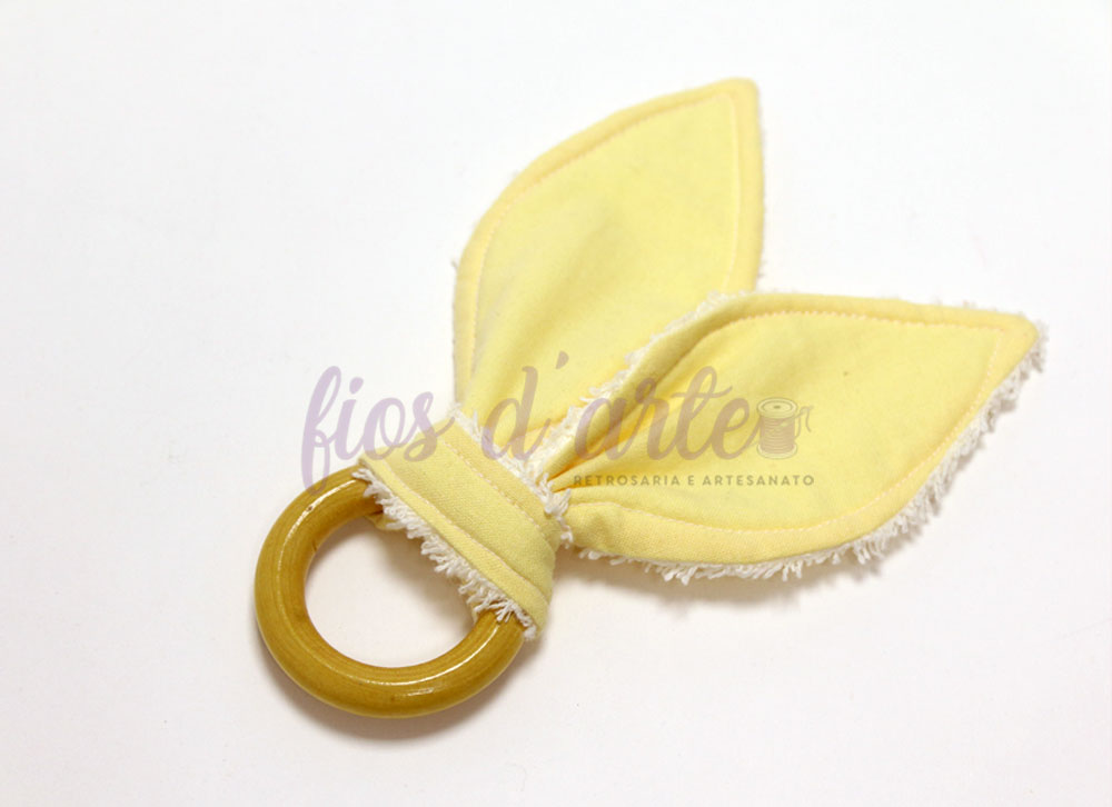 Chocalho de madeira com tecido amarelo em forma de folhas