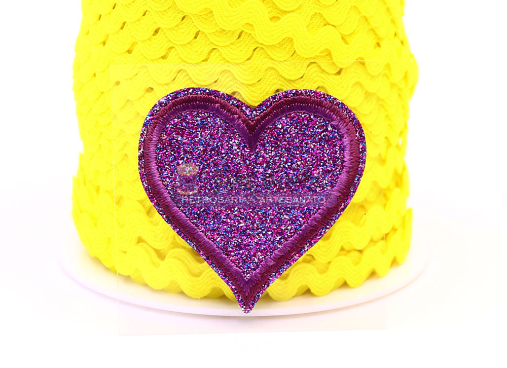 Adereço em forma de coração roxo brilhante sobre fundo amarelo ondulado