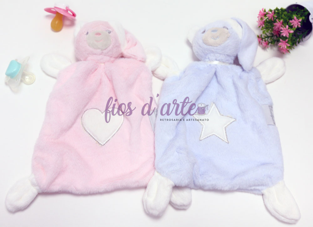 Brinquedos de pelúcia rosa e azul com corações e estrelas, biberões e vaso de flores