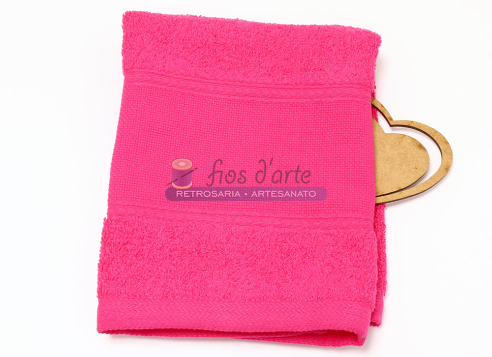 Toalha de banho vermelha com etiqueta e coração de madeira ao lado