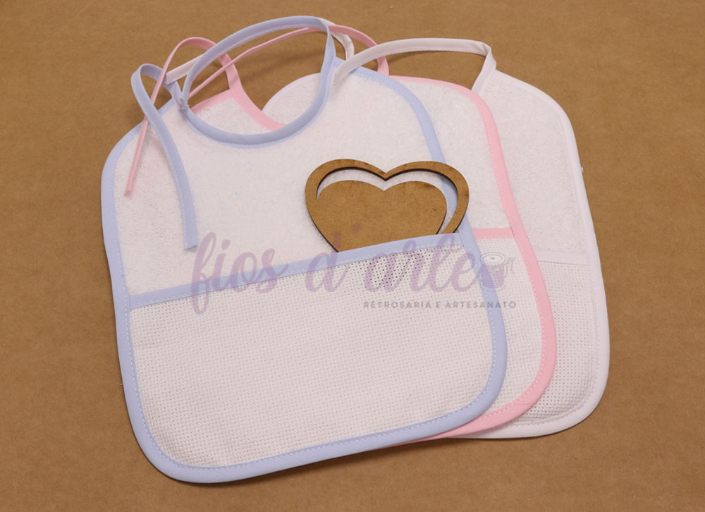 Conjunto de três babetes brancos com bordas coloridas e textura perfurada.