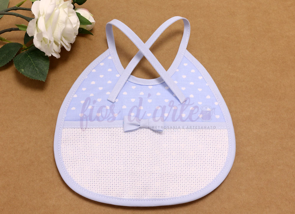 Babete de bebé azul claro com corações brancos e laço central