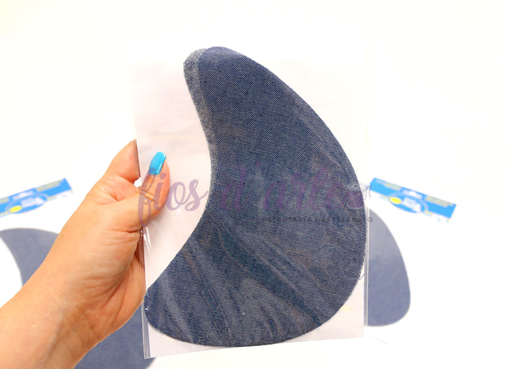 Entrepernas termocolantes I (ganga) - azul Suporte de ombro preto texturizado segurado por uma mão, com pacotes azuis e brancos ao fundo sobre superfície branca.