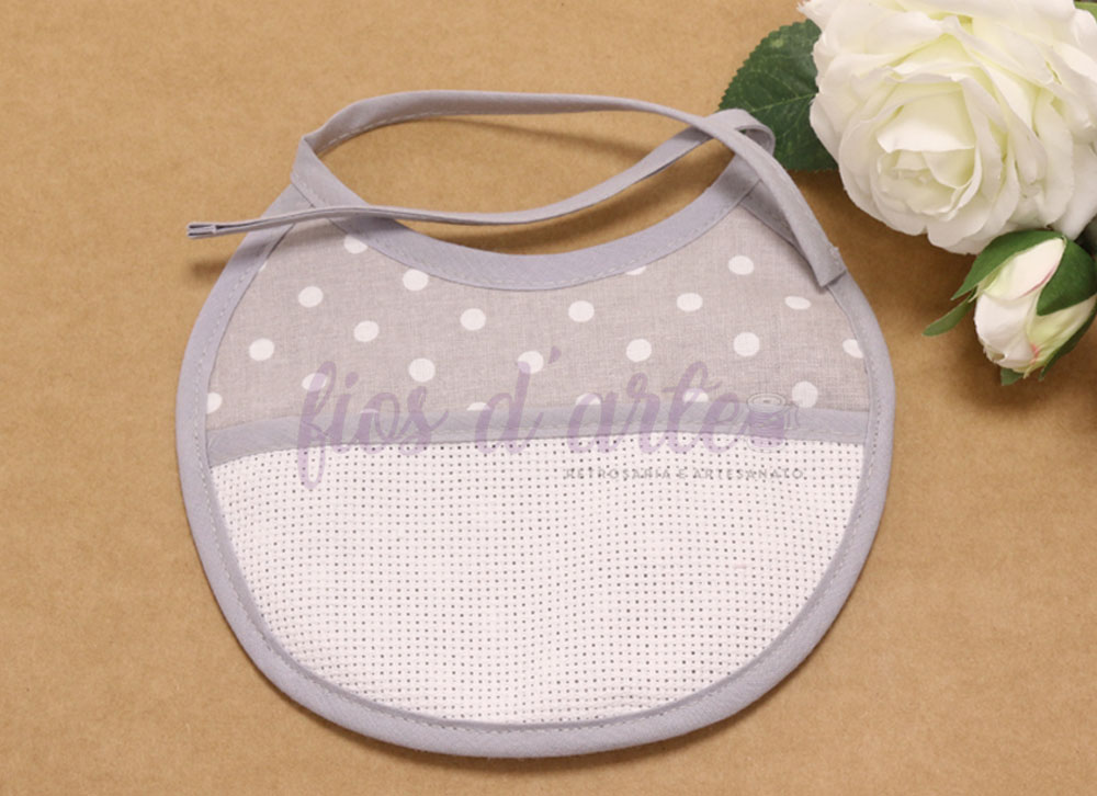 Babete redonda com turco para bordar ponto cruz - Pintinhas (Fios d'arte) Babete redondo cinzento com bolinhas brancas e parte inferior branca texturizada