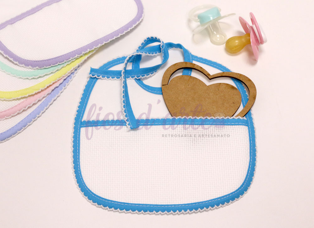Babete branco com borda azul, fita, coração de madeira e chupetas coloridas