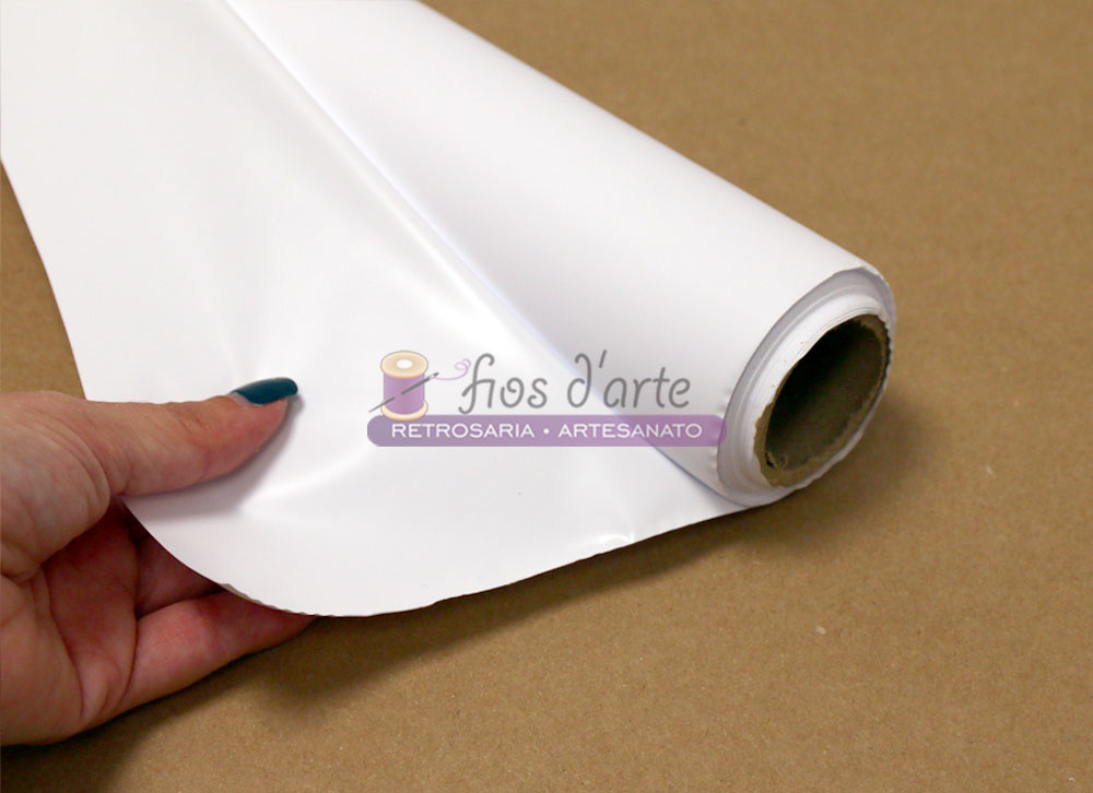Plástico alimentar impermeável (80cms) - branco Rolo de tecido branco liso segurado por mão sobre superfície castanha
