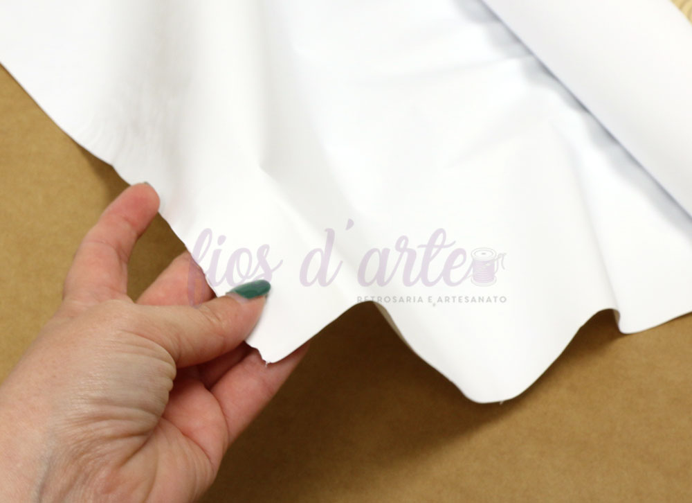 Plástico alimentar impermeável (80cms) - branco Pano branco com texto quase transparente segurado por mão sobre superfície castanha