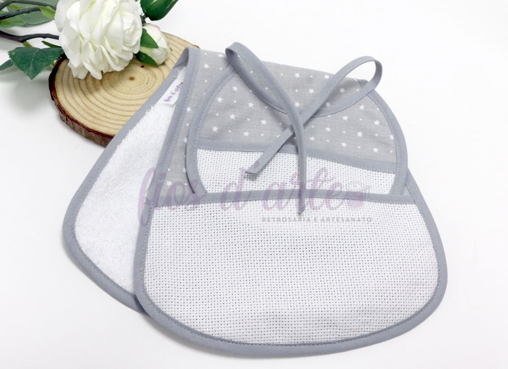 Fralda de ombro + babete com quadrilé para bordar ponto cruz #06 (Fios d'arte) Dois babetes para bebé em tecido cinzento e branco com padrão de estrelas, junto a flor branca