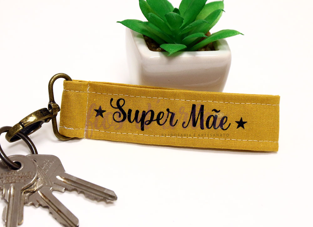 Porta-chaves amarelo mostarda com texto 'Super Mãe' e chaves