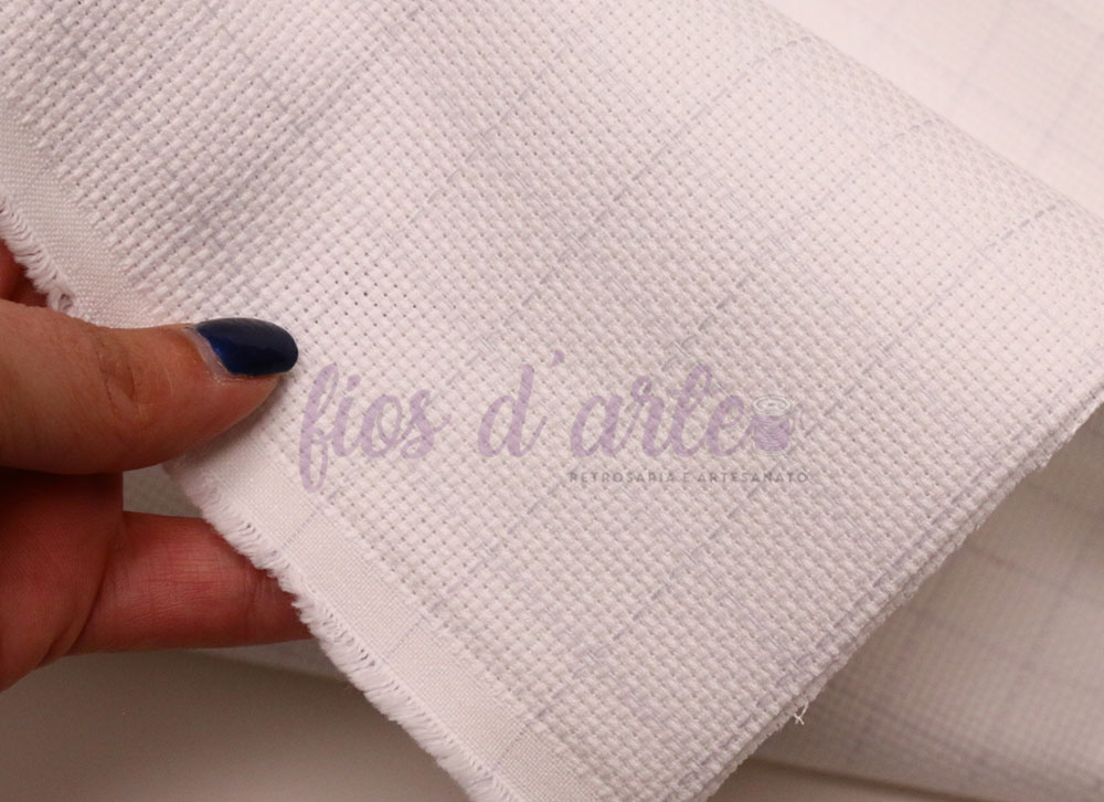 Tecido branco de algodão com padrão quadriculado segurado por mão com unhas azuis