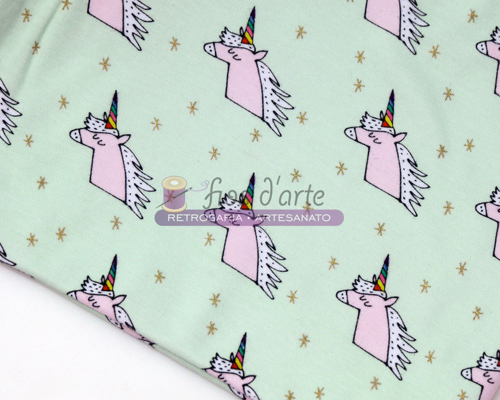 tecido verde claro com padrão de unicórnios rosa e estrelas douradas