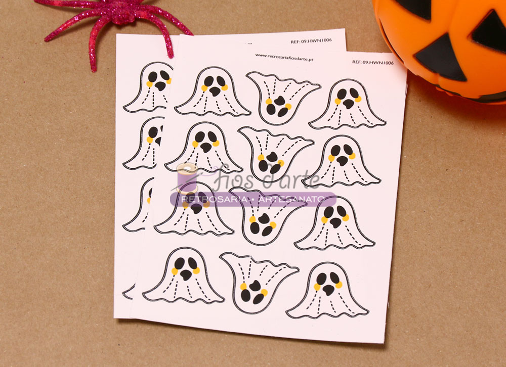 Folha com recortes de fantasmas em papel branco com aranha rosa e abóbora de Halloween