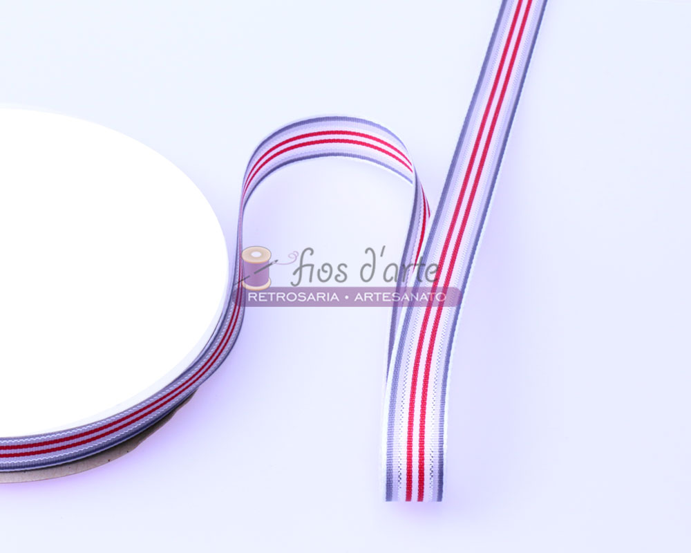 Fita decorativa branca com riscas vermelhas e azuis enrolada