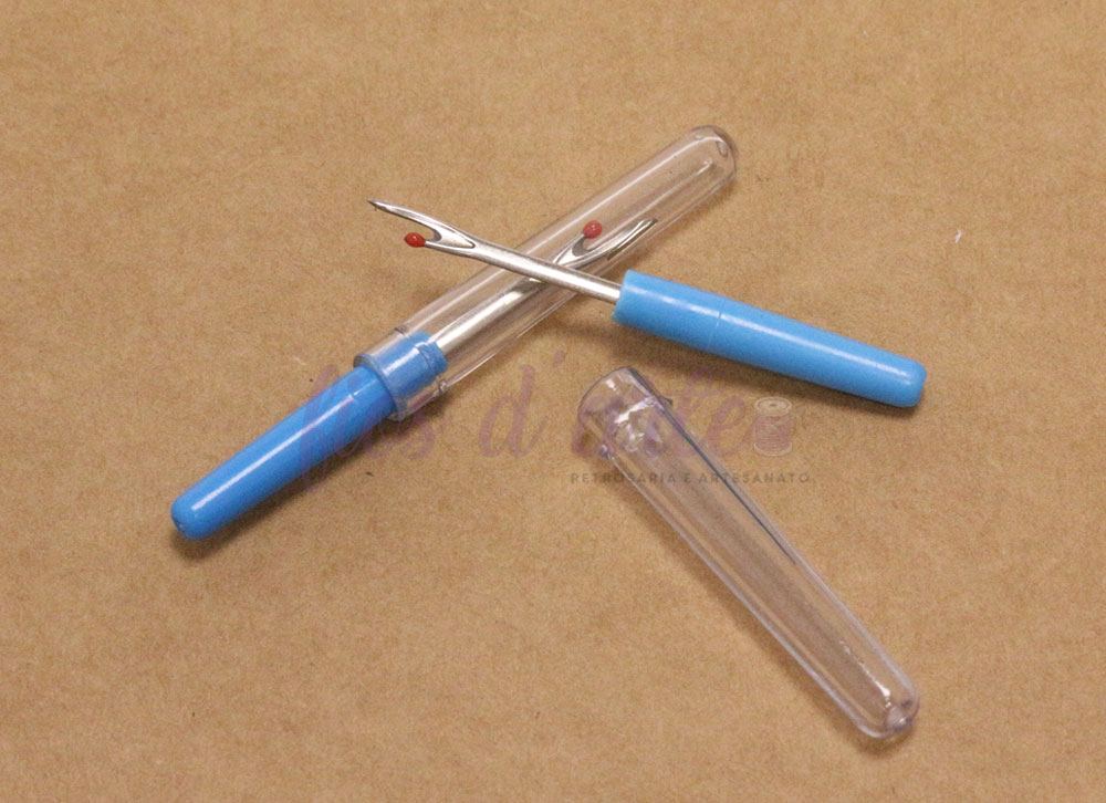 Descosedor/ Abre casas (Cose) Descosedores de linha com cabo azul e ponta metálica sobre superfície castanha