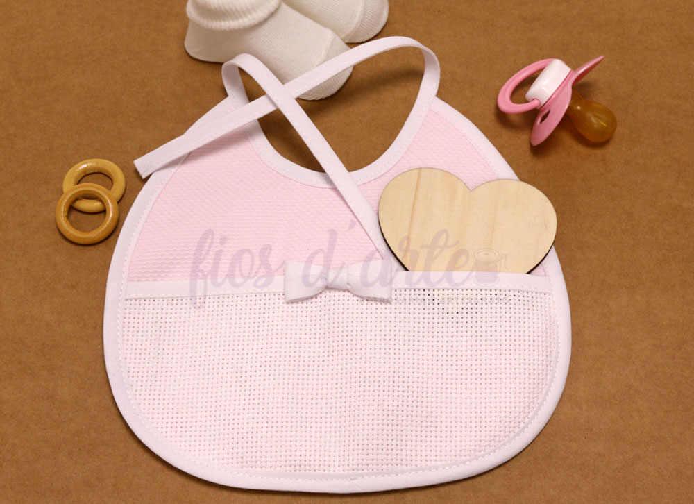 Babete em piquet com lacinho com turco para bordar ponto cruz (Fios d'arte) Babete rosa claro com bolso, coração de madeira, argolas, chupeta e meias em fundo castanho