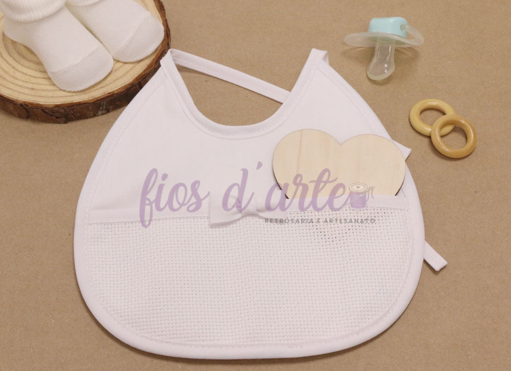 Babete com tecido liso e turco com lacinho para bordar ponto cruz (Fios d'arte) Babete branco com bolso texturizado, chupeta verde-água, anéis de madeira e meias brancas