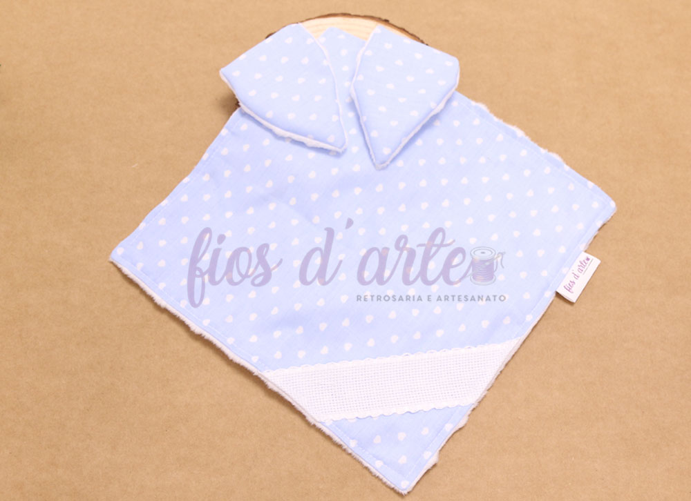 Pano azul claro com corações brancos e faixa branca sobre superfície castanha