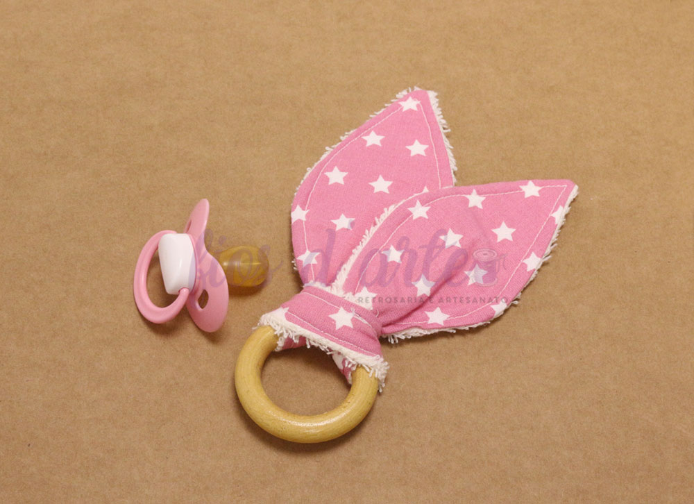 Chupeta rosa e argola de madeira com tecido cor-de-rosa com estrelas brancas