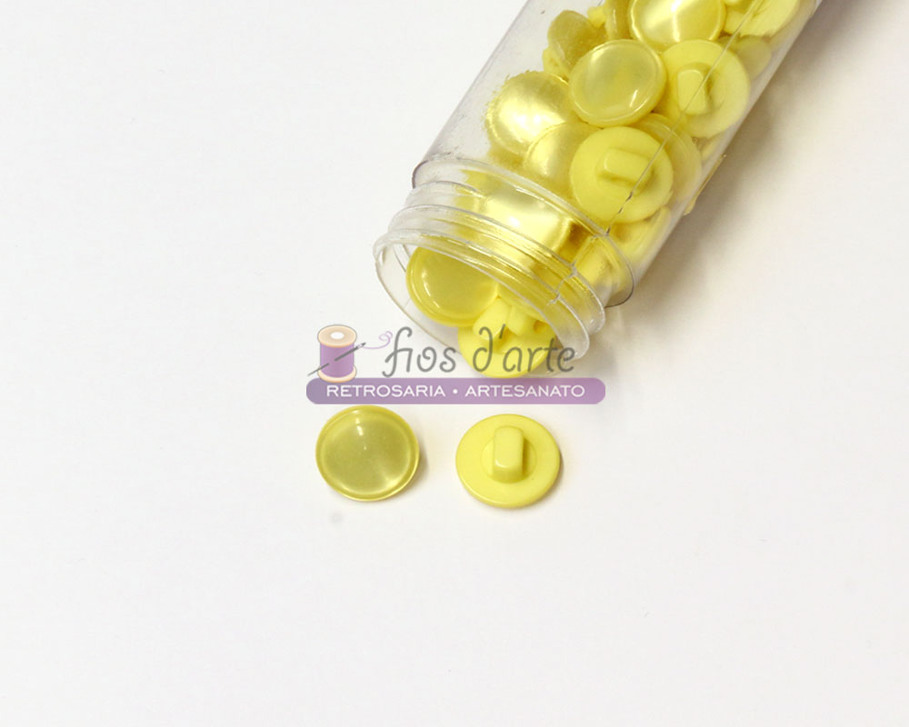 Botão redondo com pé e com brilho (12mm) Frasco transparente com botões amarelos de plástico, sobre superfície branca
