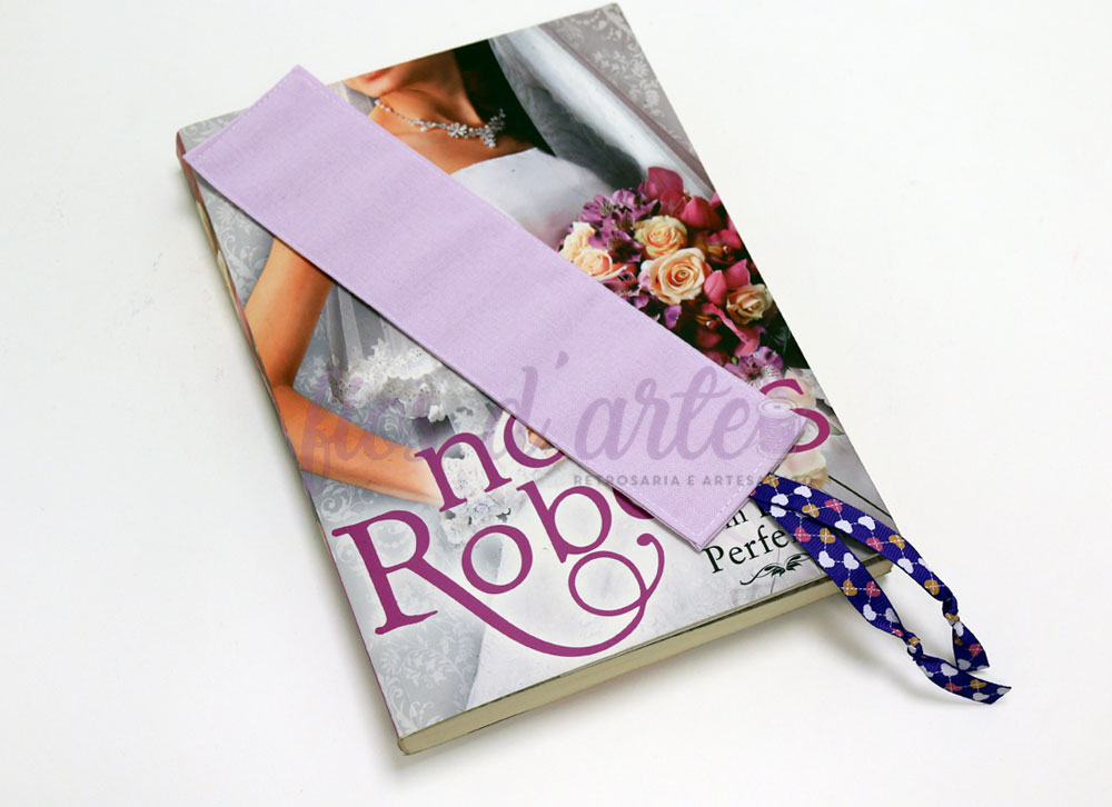 Marcador de livros longo em tecido lavanda #103 (para personalizar) Marcador de páginas lilás em tecido com fita azul e branca sobre revista de noiva