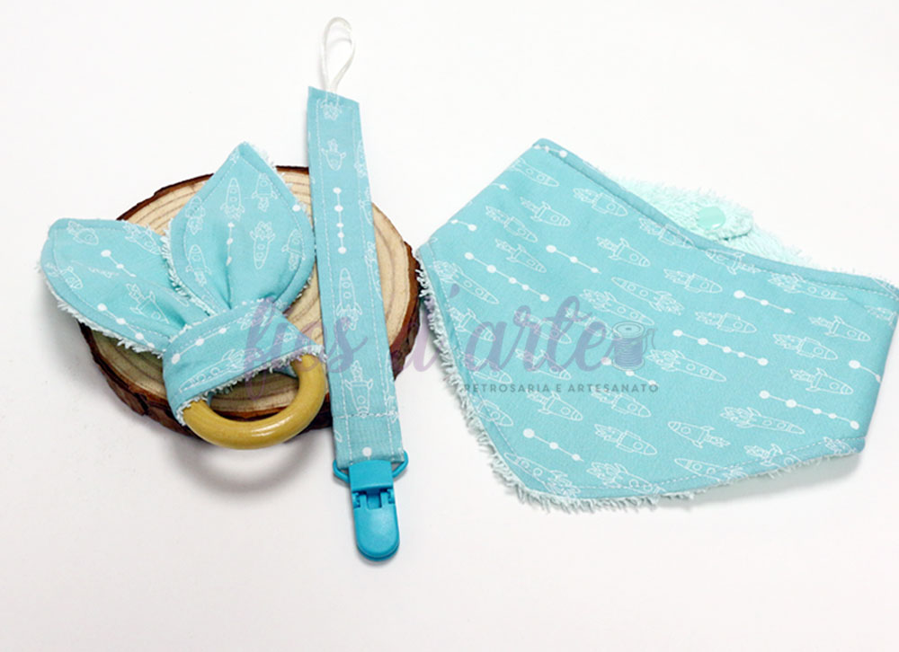 Conjunto de 3 peças para bebé - verde água (Fios d'arte) Conjunto para bebé com faixa de tecido, mordedor de madeira, fita para chupeta e babete, todos azuis com padrão de peixes brancos.