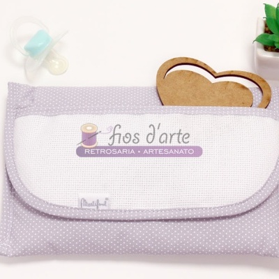Estojo lilás com pontos brancos e texto fios d'arte RETROSARIA, chupeta, molduras de coração, planta