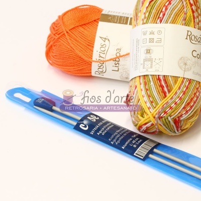 Novelos de fio colorido e agulhas de tricot em embalagem azul sobre fundo branco