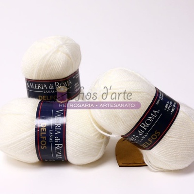 Três novelos de lã branca com etiquetas da marca Valeria di Roma.