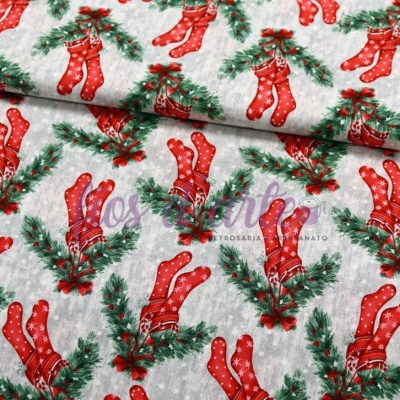 Tecido natalício com padrão de meias vermelhas e folhas verdes sobre fundo cinzento com pontos brancos.