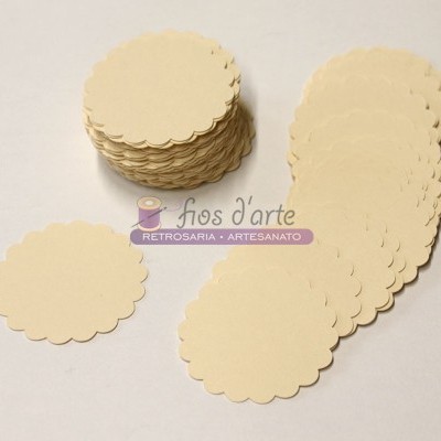 Etiquetas de papel creme com bordas onduladas empilhadas e dispostas em fundo branco