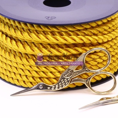 Rolo de corda amarela com etiqueta e duas tesouras douradas