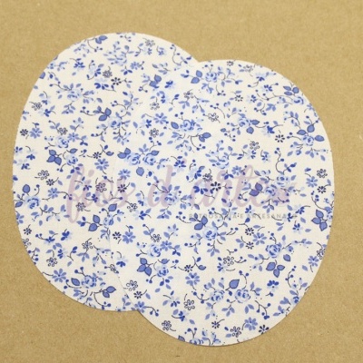 Discos redondos de tecido com padrão floral azul e branco e palavra 'mulher' em roxo.